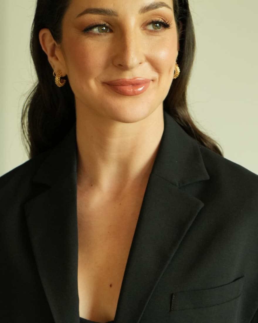 Head-and-shoulders portrait of Anne-Sophie Fluri in a black blazer against a plain cream background