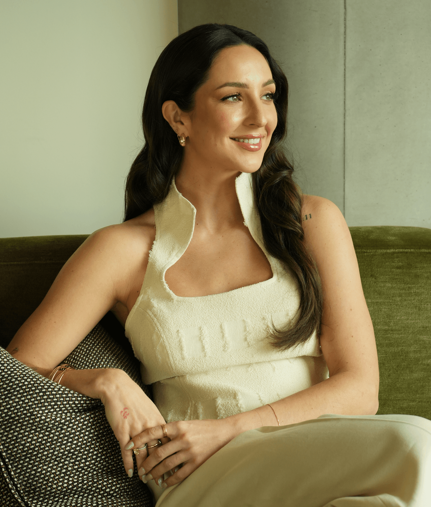 Anne-Sophie Fluri, founder of Brainwave, seated on a green velvet sofa and looking away from the camera