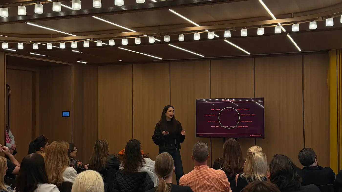 A sleep talk under way at Hotel Cafe Royal, the speaker beside a wall-mounted screen with the audience seated in front of her