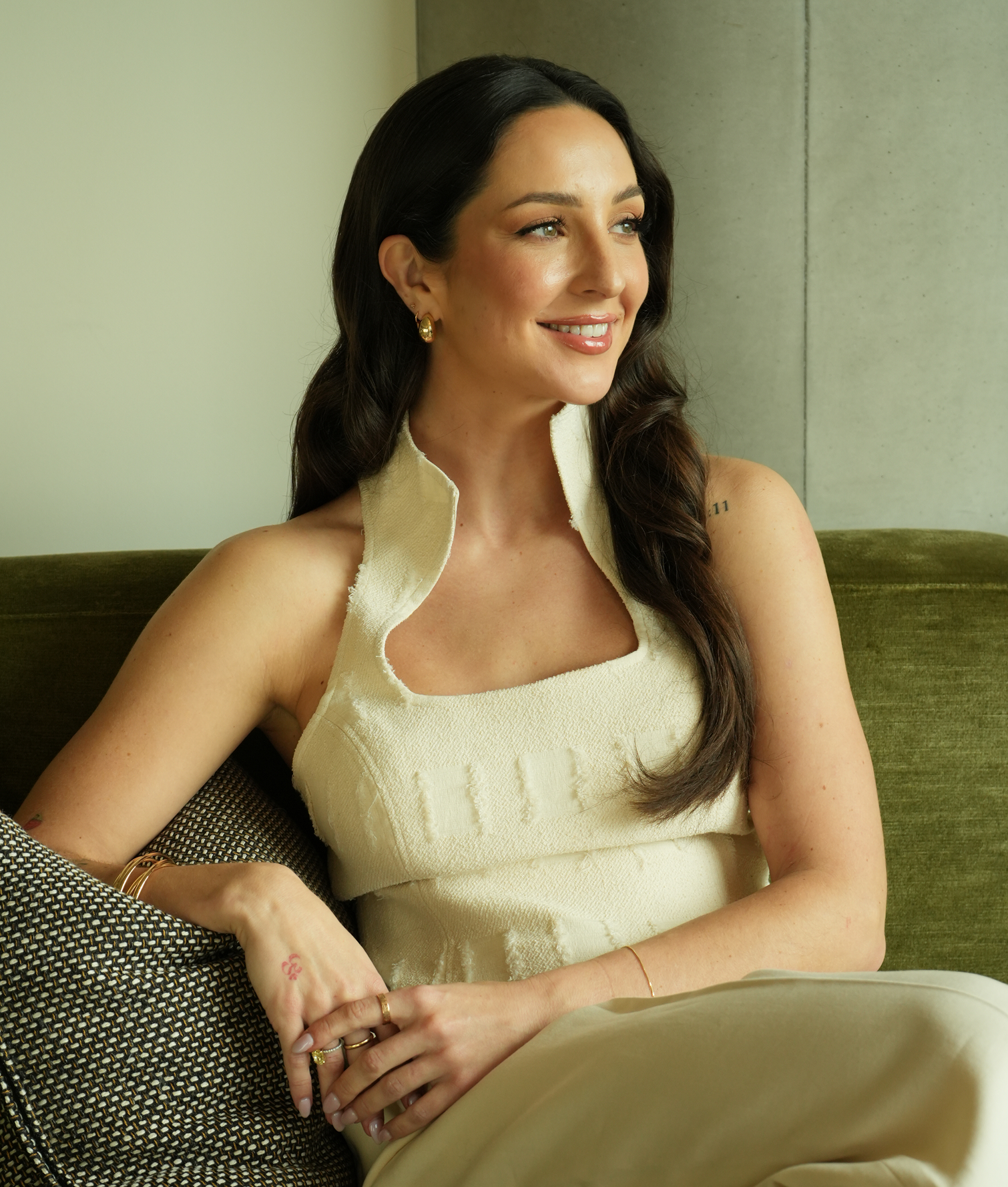 Anne-Sophie Fluri, founder of Brainwave, seated on a green velvet sofa and looking away from the camera